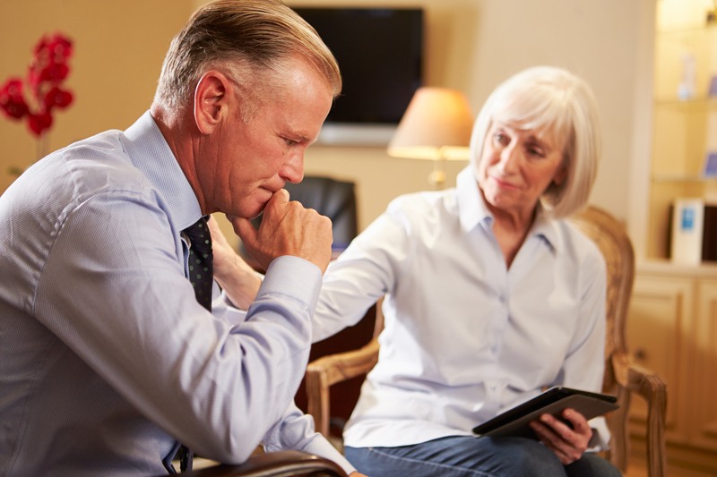 Man Talking To Female Counsellor Using Digital Tablet Man Talking To Female Counsellor