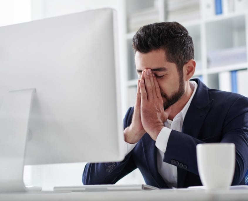 Online Counselling in United Kingdom - Mental Wellness Counselling frustrated man sat in front of a computer screen having online counselling