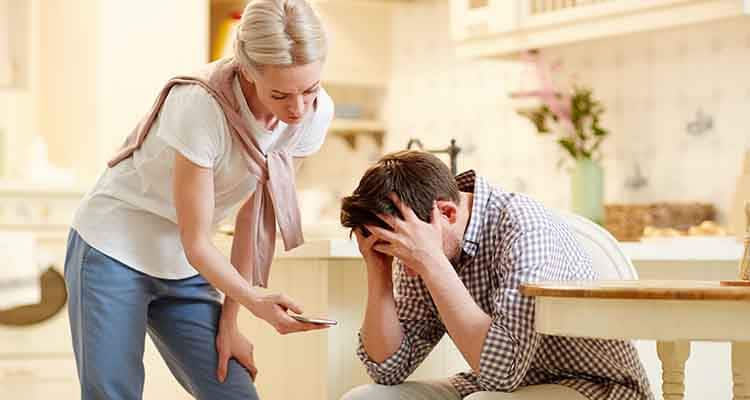 Common-Relationship-Problems A woman is trying to solve conflict whereas she is trying to show something on phone